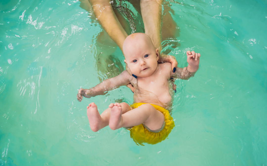 Pool Rules Cause Diaper Dilemma - baby in pool with woman's arms holding it floating